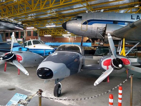 A collection of vintage propeller planes and historic aircraft inside a hangar at the Flight of the Phoenix Aviation Museum in Gilmer, Texas.
