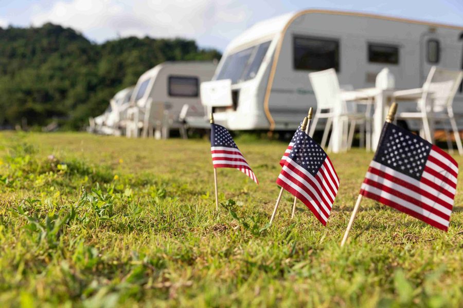 Manufactured home parked on a residential lot in a quiet mobile home park community with pine trees and well-maintained streets, representing tenant-owned home lot (TOH) rentals