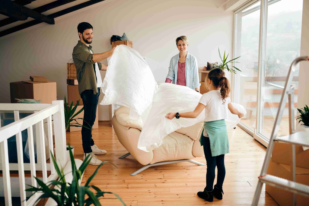 Family moving into new home during spring season with green trees, warm weather, and welcoming community representing spring relocation season, ideal timing