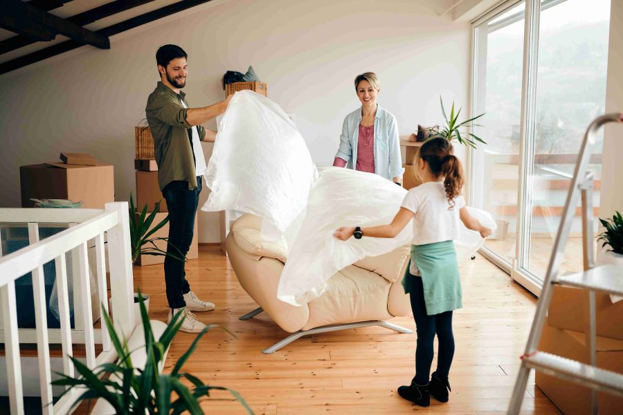 Family moving into new home during spring season with green trees, warm weather, and welcoming community representing spring relocation season, ideal timing