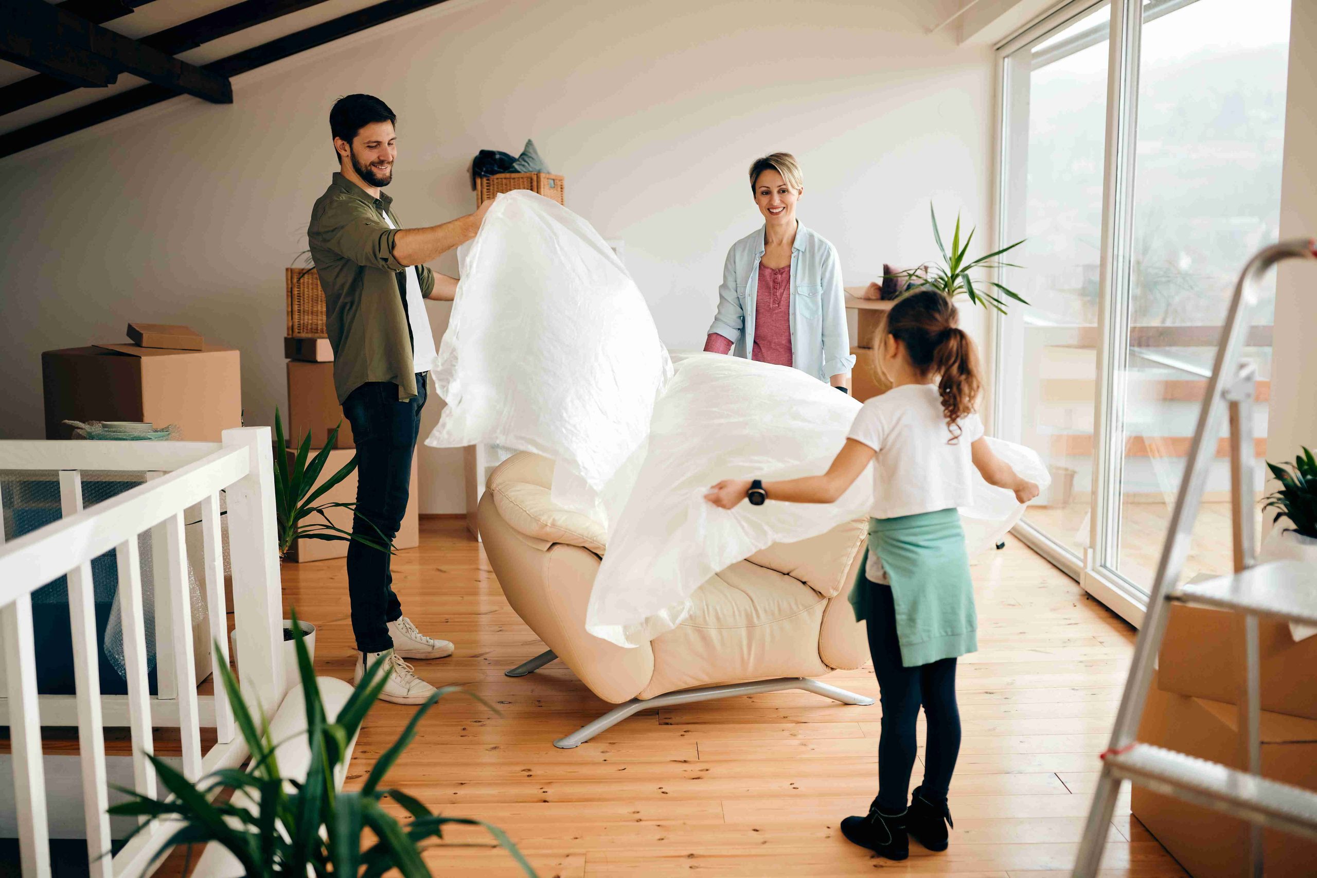Family moving into new home during spring season with green trees, warm weather, and welcoming community representing spring relocation season, ideal timing